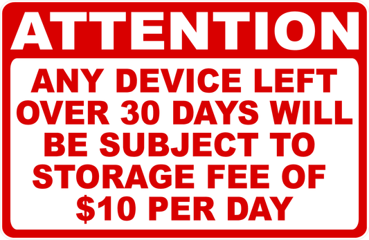 A rectangular warning sign with a red border, red header, and red text on a white background reading: 'ATTENTION ANY DEVICE LEFT OVER 30 DAYS WILL BE SUBJECT TO STORAGE FEE OF $10 PER DAY'.