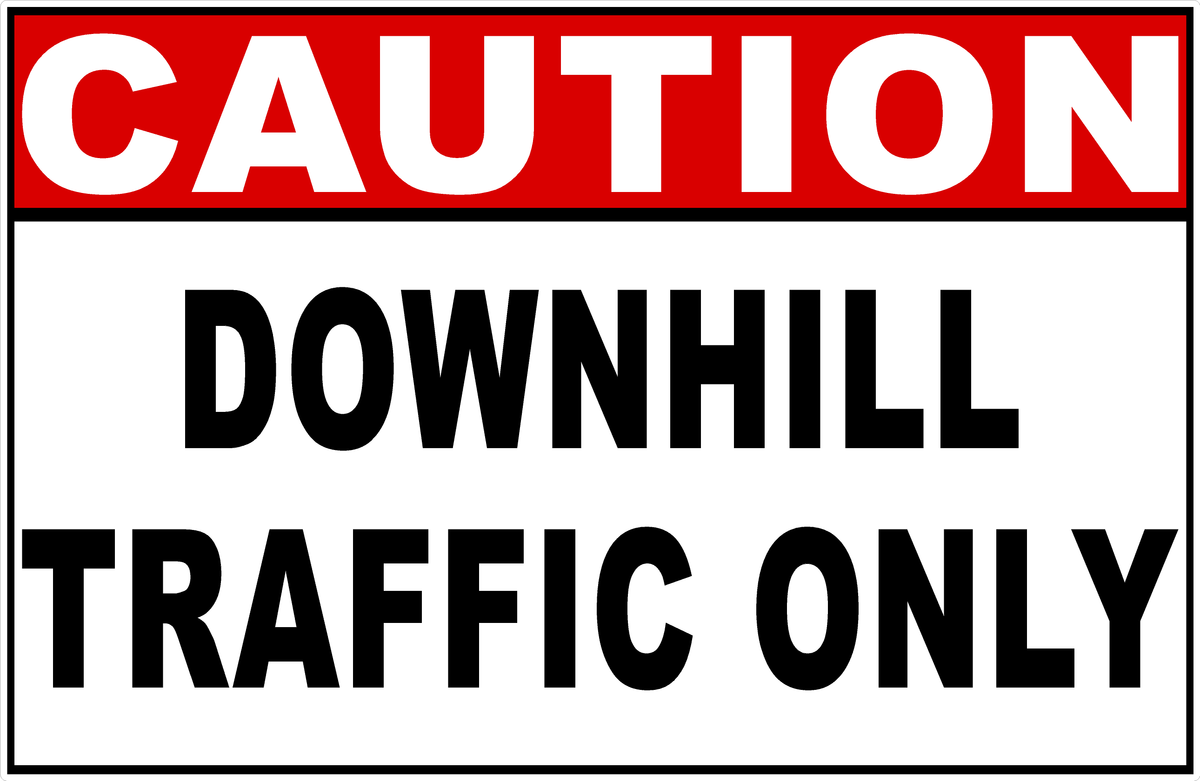 A rectangular traffic sign with a red header reading 'CAUTION' in white letters and large black text below reading 'DOWNHILL TRAFFIC ONLY' on a white background.