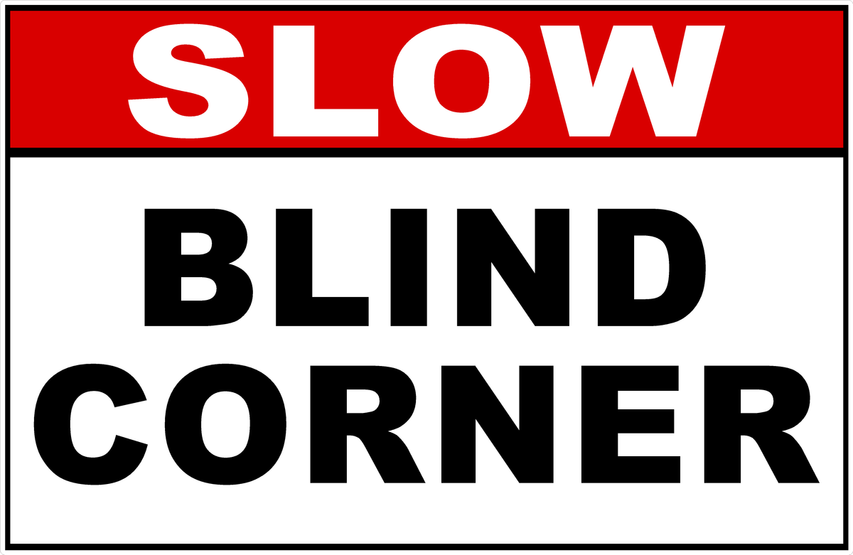 A rectangular warning sign with a red header reading 'SLOW' in white letters and large black text below reading 'BLIND CORNER' on a white background.